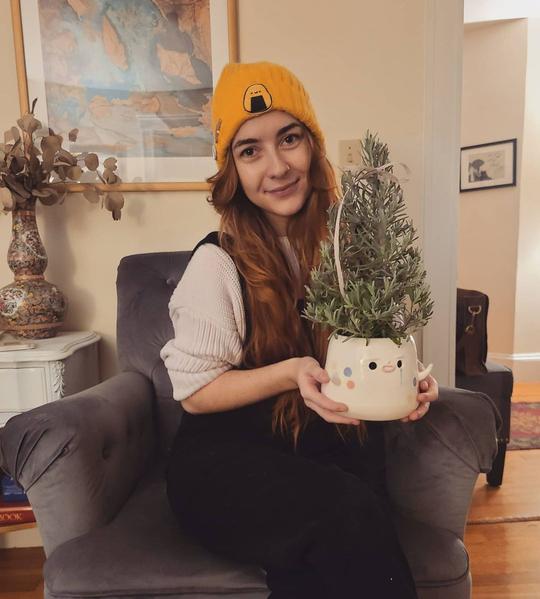 featured image of woman holding a ceramic pot with a small christmas tree in it